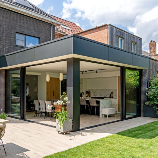 Deze woonveranda is een overdekte, glazen of halfopen ruimte die aan de woning is aangebouwd. Het vormt een elegante overgang tussen binnen en buiten, beschermd tegen regen, wind en zon. De veranda heeft een schuifraam, waardoor open ruimte en een mooi uitzicht op de tuin mogelijk zijn. De veranda biedt een open ruimte waarin je kunt genieten van het uitzicht op de tuin, terwijl je toch beschut bent. Een veranda wordt gebruikt als gezellige plek om te ontspannen, te eten of gasten te ontvangen.